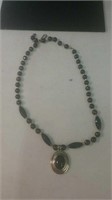 Black bead and gold tone necklace with pendant