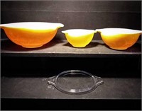 Three Pyrex nesting bowls, two have a flower