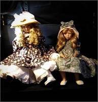 Two porcelain dolls in sitting positions one with