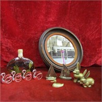 Brass figures, framed mirror, glass bottle.