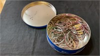 Lidded tin filled with silver tone bracelets -some