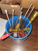 bucket of screw drivers and socket drivers
