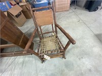 Old wooden rocking chair w/woven rope seat