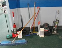 Assortment of brooms, vacs, cleaning items.