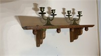 Small oak wall shelf with two brass candlesticks.