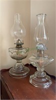 Two clear glass oil lamps - one antique press