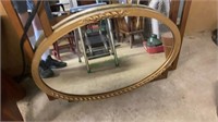 Gold wood framed oval mirror measures 32 x 22