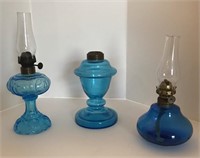 Three miniature oil lamps in blue 4.5” to 6” tall.