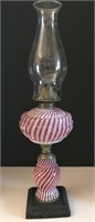 Cranberry opalescent swirl oil lamp, 14”. (crack.)