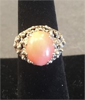 Gold ring in a fancy setting with a cabachon coral