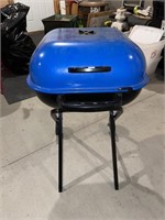 blue americana charcoal grill with a locking lid