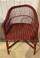 Small red painted wicker armchair with no