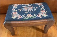 Small footstool with a needlepoint padded top.