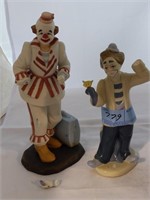 Two clown figurines both with broken hands
Note