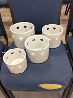 Set of four white pottery planters with heart cut