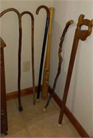 5 walking canes and a carved bat