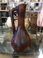 Tall antiqued brown colored pottery jug