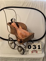 Vintage wicker doll stroller with porcelain doll.