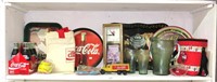 Shelf lot of Coca Cola items including glass