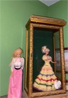 Gold framed showcase with 2 Barbie doll, one