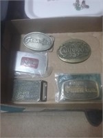 Group of five belt buckles including a C