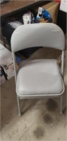 Gray metal padded folding chair rips in upper pad