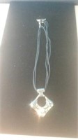 Cord necklace with silver tone pendant