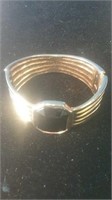 Gold tone clasp bracelet with dark stone