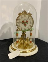 Clock with metal base, glass globe, wind up.