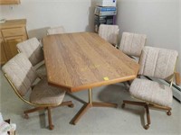 Table with 6 Rolling Upholstered Chairs