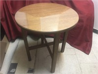 Round solid oak side table on four legs.