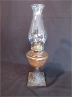 An Antique Oil Lamp With Cast Iron Base