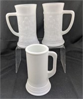 Three milk glass mugs one plain two with bar