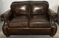 BROWN LEATHER LOVESEAT WITH NAILHEAD TRIM
