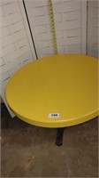 small yellow table with wrought iron legs