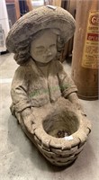 Little girl with sun hat in a basket concrete