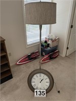 Large wall clock and tall floor lamp