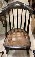 Small antique rocking chair with a woven cane