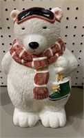 Ceramic polar bear cookie jar holding a pair of