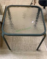 Small square metal patio table with wavy glass