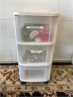 Wheeled plastic storage tote full of craft items