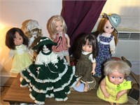 GROUP OF DOLLS ON TOP OF TABLE, APPROX 7 PIECES