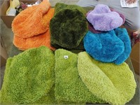 lot of toliet seat covers w/ matching rugs
