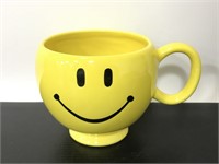 Yellow ceramic drinking mug with smiley face