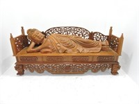 Carved figure of recumbant lady on bench,