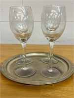 Etched grape wine glasses sitting on plate