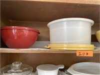 Shelf of misc bowls and cake keeper.