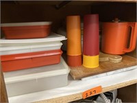 Shelf of misc Tupperware and cutting boards.