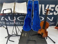violin in case with guitar stands and music book