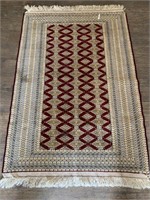 Hand woven wool rug fringed length is 80" x 52"